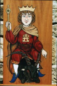 Pintura sobre madera en estilo medieval de un rey niño de frente con corona, cetro y capa dorados, sentado sobre un macho cabrío negro doblegado