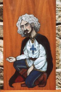 Pintura sobre madera en estilo medieval de un caballero de mediana edad con cabello cano y barba castaña, capa negra, camisa blanca con flor de lys azul semiarrodillado