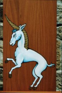 Pintura sobre madera en estilo medieval de un unicornio blanco de perfil con cuerno dorado y crines celestes
