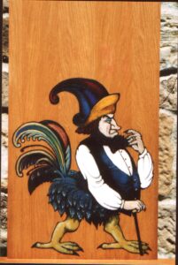 Pintura sobre madera en estilo medieval de un burgués de perfil con gorro de colores, camisa blanca y chaleco azul, cola y patas de gallina