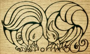 Pirograbado sobre roble de una oca y un águila con sus cuellos entrelazados mordiéndose mutuamente las patas