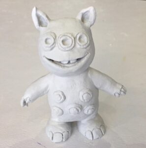 Fotografía de una escultura en arcilla blanca de Chipirisblustio el cocoleyo, un extraterrestre pleyadiano de tres ojos.