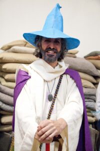 Fotografía de Aislami con pelo medio largo y barba, ataviado con vestiduras de mago